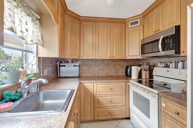 kitchen featuring white range with electric cooktop, light tile patterned flooring, sink, and tasteful backsplash