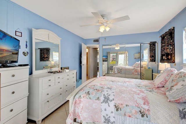 bedroom featuring ceiling fan, light tile patterned floors, and a closet