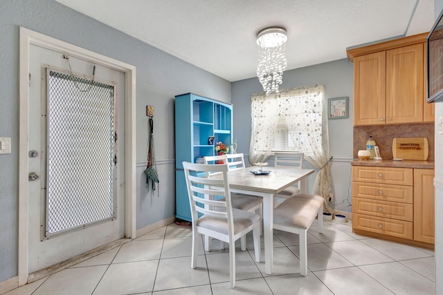 dining room with a chandelier and light tile patterned floors