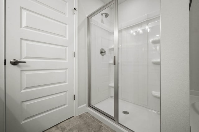 bathroom with tile patterned floors and a shower with shower door