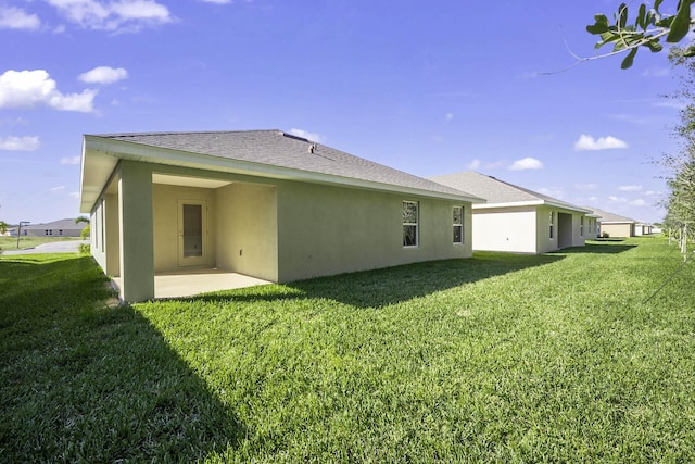 back of property with a yard and a patio