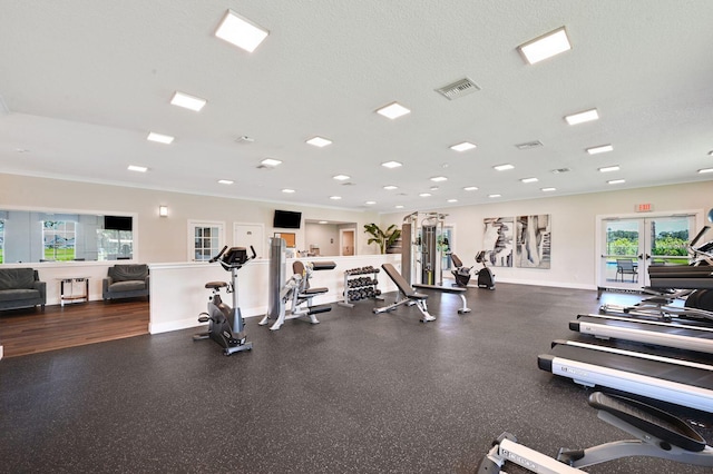 gym with ornamental molding, a textured ceiling, and french doors