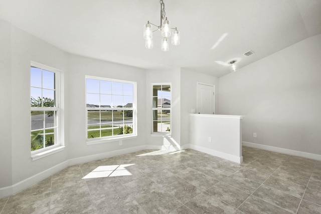 unfurnished room with plenty of natural light and an inviting chandelier