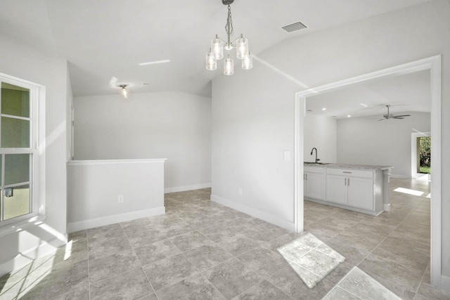 empty room with ceiling fan with notable chandelier, lofted ceiling, and sink