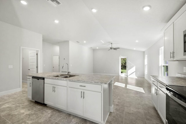 kitchen with lofted ceiling, a center island with sink, white cabinets, sink, and stainless steel appliances