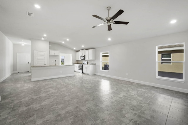 unfurnished living room featuring ceiling fan, light tile patterned floors, a healthy amount of sunlight, and lofted ceiling