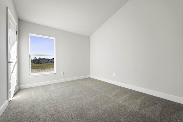 empty room featuring lofted ceiling and carpet floors