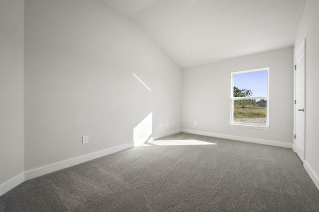 carpeted empty room featuring lofted ceiling