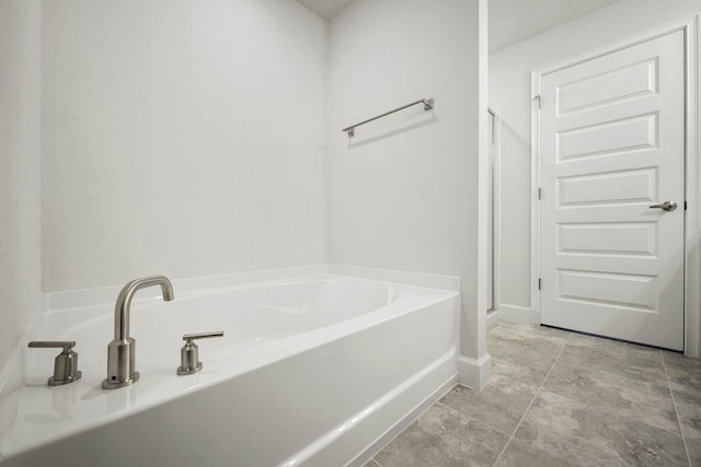 bathroom featuring tile patterned flooring and a bath