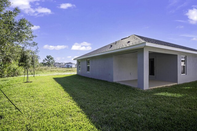 rear view of property featuring a patio area and a yard