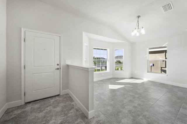 entryway featuring a notable chandelier, light tile patterned flooring, lofted ceiling, and a wealth of natural light