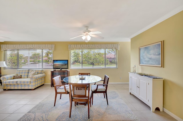 dining room with ceiling fan, ornamental molding, and light tile patterned floors