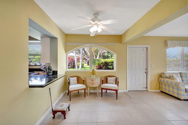 sitting room featuring ceiling fan, sink, and light tile patterned floors