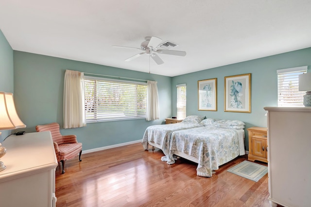 bedroom with multiple windows, light hardwood / wood-style flooring, and ceiling fan