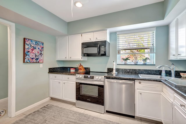 kitchen with stainless steel appliances, sink, light tile patterned floors, and white cabinets