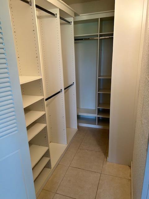 walk in closet with a barn door and light tile patterned flooring