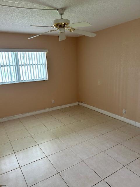 spare room featuring light tile patterned floors and a textured ceiling