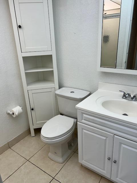 bathroom featuring tile patterned flooring, vanity, and toilet