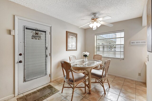 dining area with a textured ceiling, ceiling fan, and light tile patterned floors