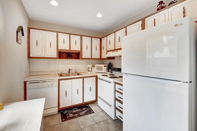 kitchen with white cabinetry, light tile patterned floors, white appliances, and sink