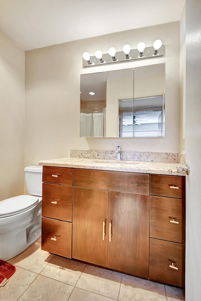 bathroom featuring vanity, tile patterned flooring, and toilet