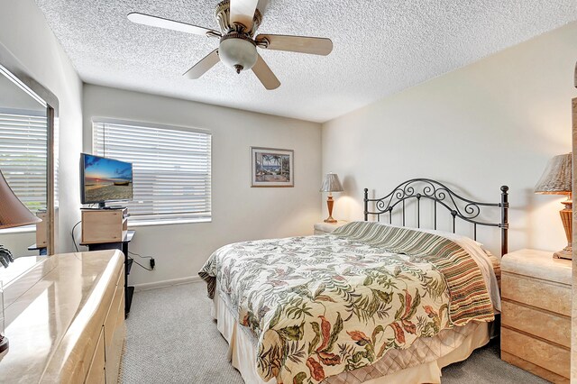 carpeted bedroom featuring a textured ceiling and ceiling fan