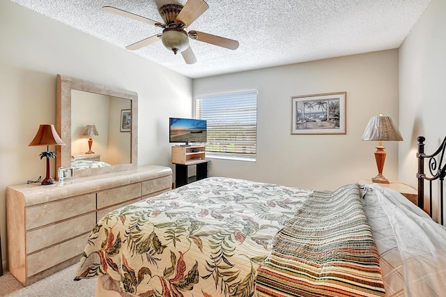 bedroom with ceiling fan, a textured ceiling, and carpet flooring