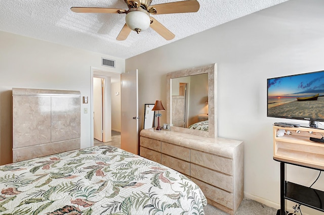 carpeted bedroom with ceiling fan and a textured ceiling