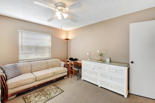 living room featuring ceiling fan, carpet flooring, and a textured ceiling