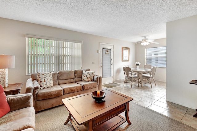 tiled living room with ceiling fan and a textured ceiling