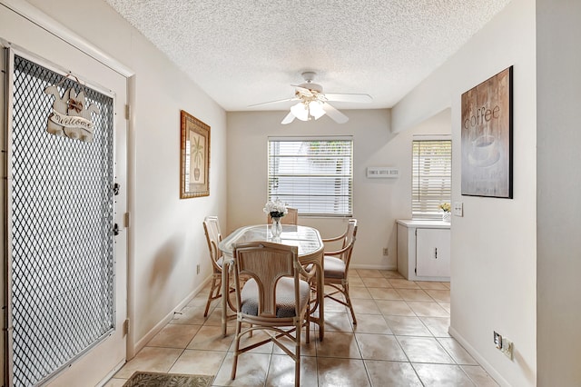 tiled dining space featuring a textured ceiling and ceiling fan