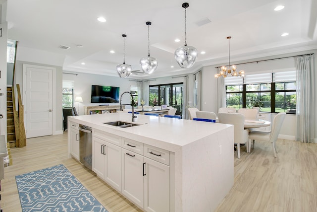 kitchen with a kitchen island with sink, white cabinetry, a wealth of natural light, sink, and a raised ceiling