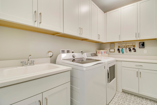 clothes washing area with cabinets, washer and clothes dryer, and sink