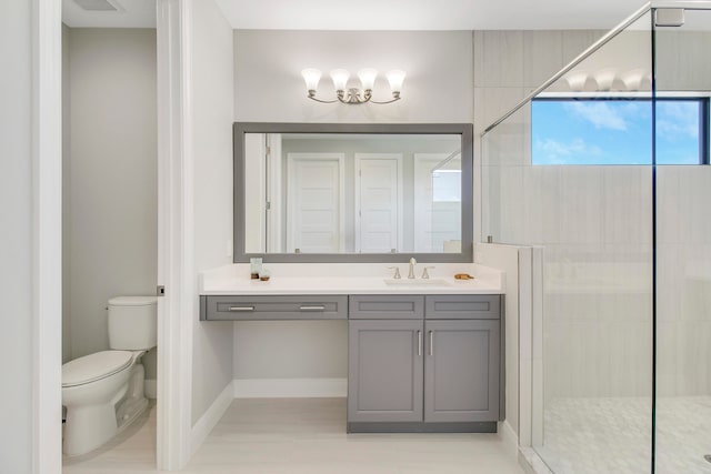 bathroom with vanity, toilet, and a shower with shower door