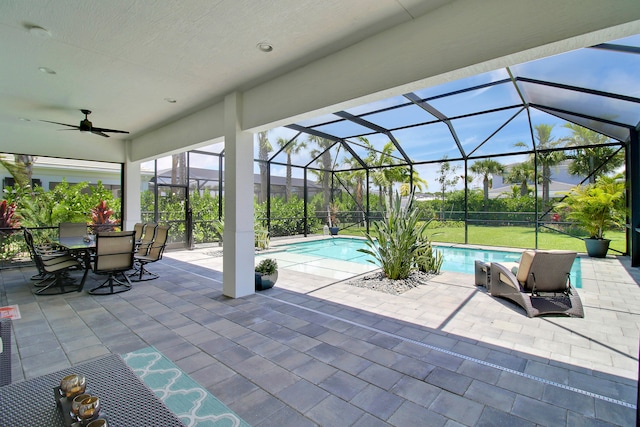 view of patio featuring ceiling fan and a lanai