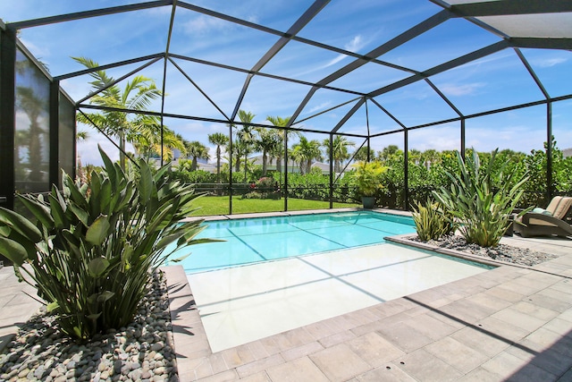 view of pool with a patio area and glass enclosure