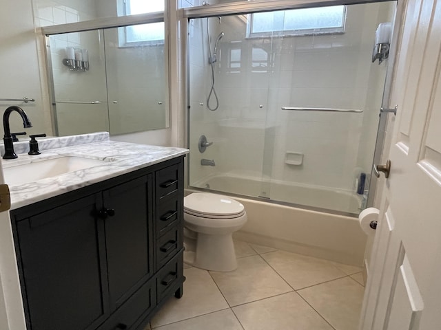 bathroom with tile patterned flooring, vanity, shower / bath combination with glass door, and toilet