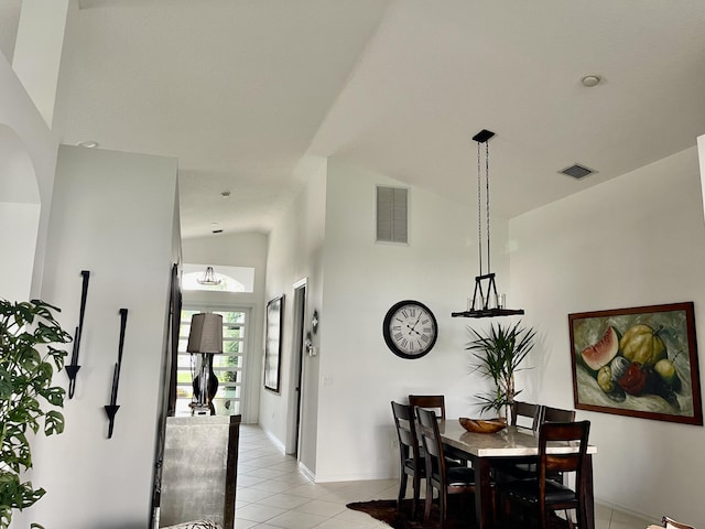 dining room with light tile patterned flooring, lofted ceiling, visible vents, and baseboards
