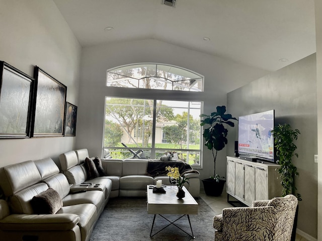 living area with light tile patterned floors, vaulted ceiling, and visible vents
