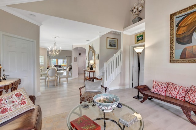 living room with crown molding, light hardwood / wood-style floors, and a notable chandelier