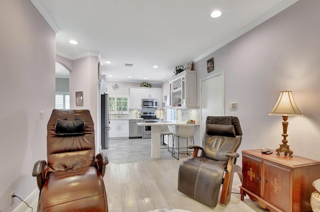 living room with light hardwood / wood-style floors and ornamental molding