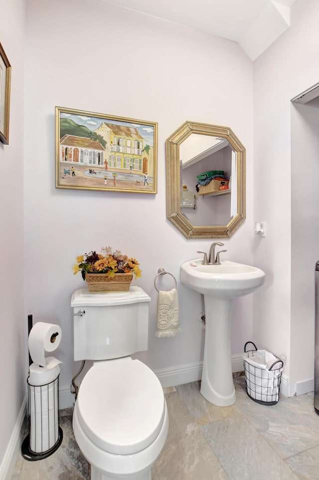 bathroom with sink, toilet, and lofted ceiling