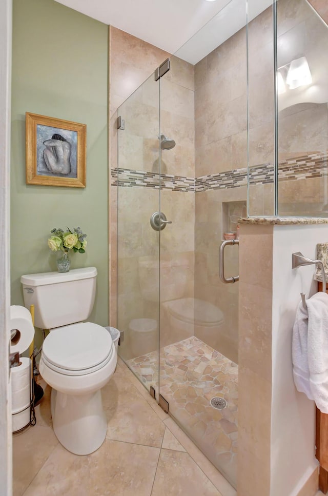 bathroom featuring tile patterned floors, toilet, and walk in shower