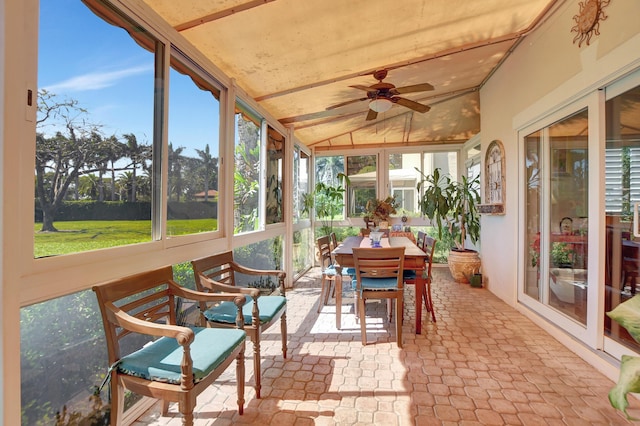 sunroom with ceiling fan, a wealth of natural light, and lofted ceiling