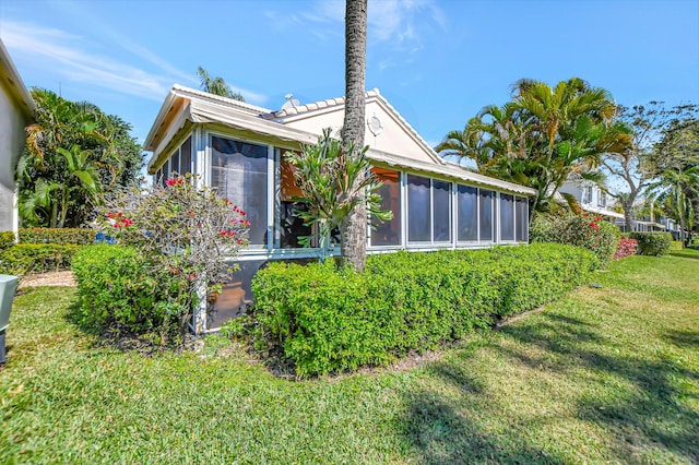 rear view of property with a sunroom and a lawn