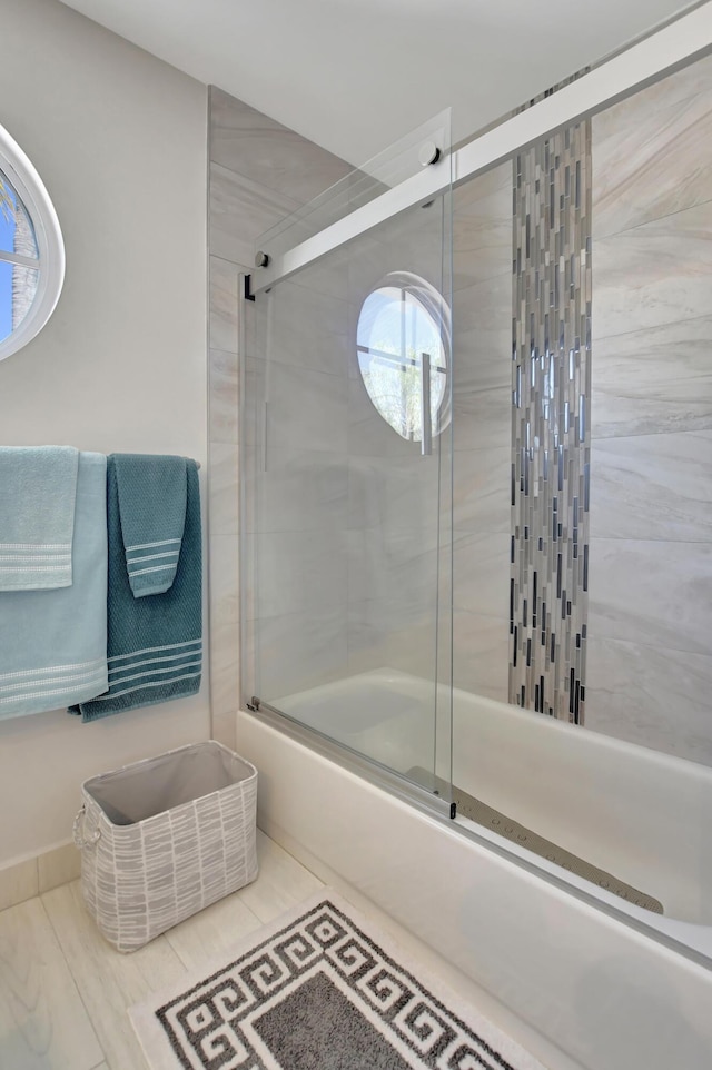 bathroom featuring combined bath / shower with glass door and tile patterned flooring