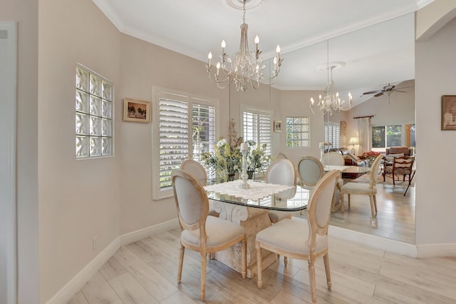 dining room with ceiling fan with notable chandelier, plenty of natural light, crown molding, and vaulted ceiling