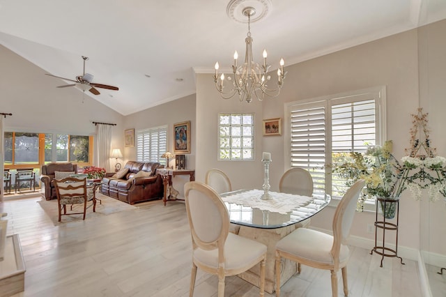 dining area featuring light hardwood / wood-style floors, ceiling fan with notable chandelier, ornamental molding, and vaulted ceiling