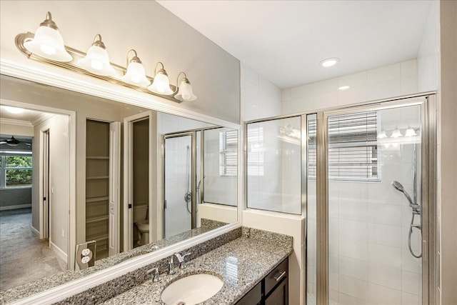 bathroom featuring vanity, toilet, ornamental molding, and walk in shower