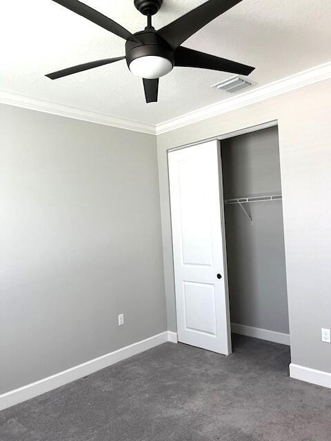 unfurnished bedroom featuring a closet, ceiling fan, and crown molding